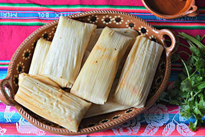 Tamales messicani tradizionali cotti al vapore in foglia di mais
